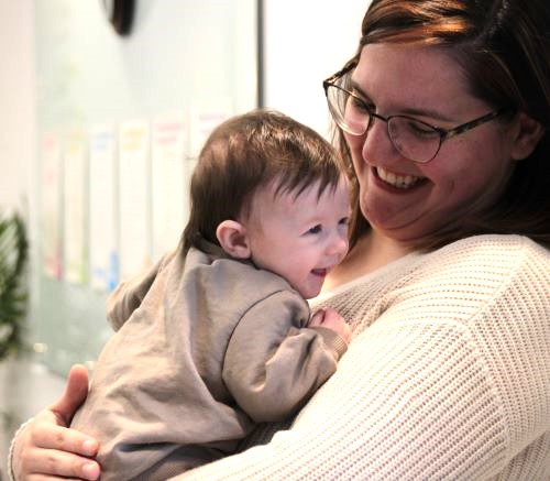 Mom holding baby laughing together